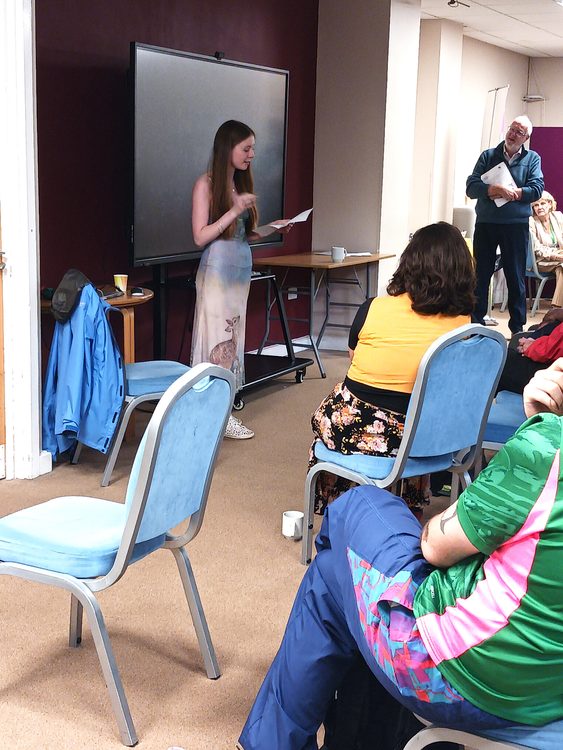 a person reading a poen to a group of people